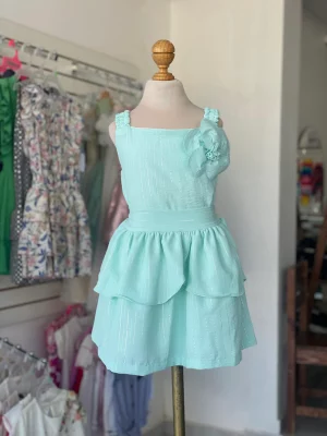 34335. Conjunto de falda de olanes y detalle de flor al hombro