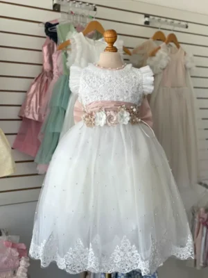 34523. Vestido con cinto y moño en tono rosa en tul, perlas y encaje